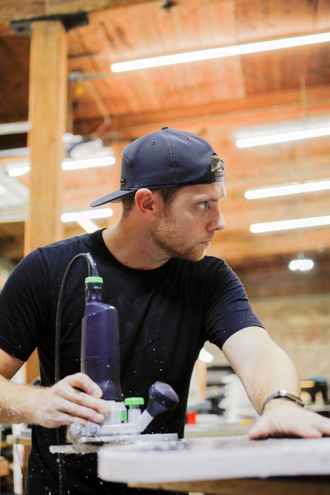 Kyle focused, routing a piece in the workshop