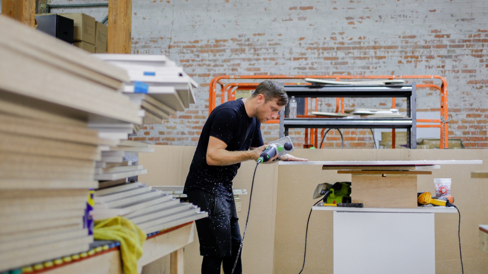 Kyle working in the KBD studio, brick walls and stacked wood